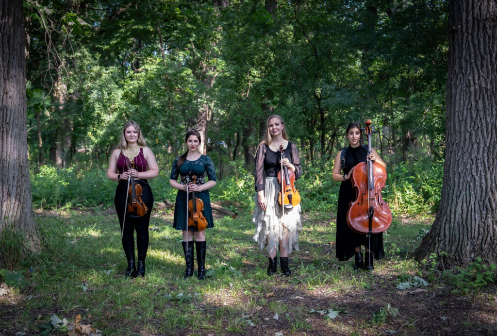ATLYS standing with their instruments in a sunlit forest